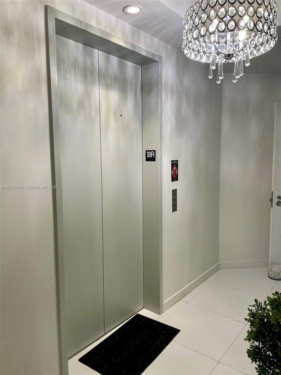 A silver elevator door with a unit number sign is located in a modern hallway — 851 NE 1st Ave # 1808, Miami FL 33132, MIAMI, FL