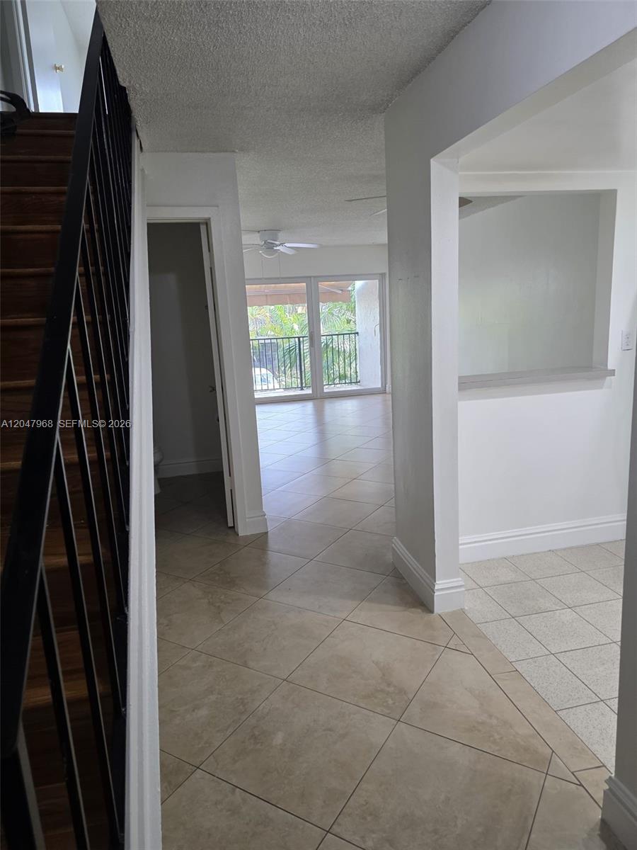 A tiled entryway leads to a living area with a balcony and a staircase — 40 NW 87th Ave # D201, Miami FL 33172, MIAMI, FL