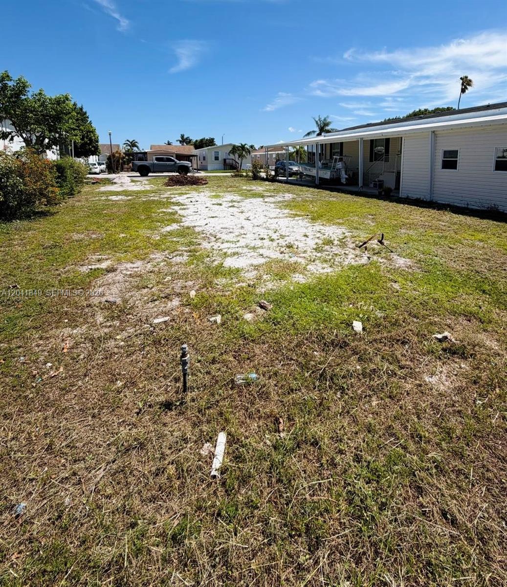 A vacant, grassy lot with a patch of white gravel next to a mobile home — 2651 E Marina Dr, Dania Beach FL 33312, DANIA BEACH, FL