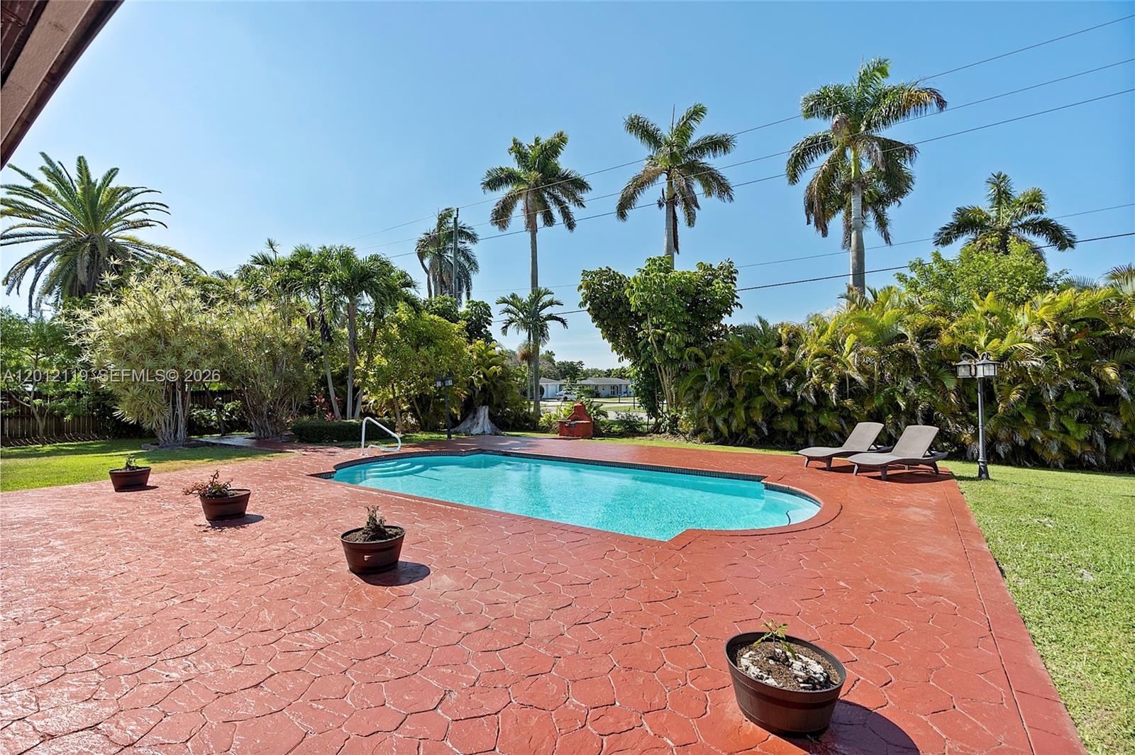 A backyard features a swimming pool surrounded by a red stamped concrete patio and palm trees — 8895 SW 184th Ter, Cutler Bay FL 33157, CUTLER BAY, FL