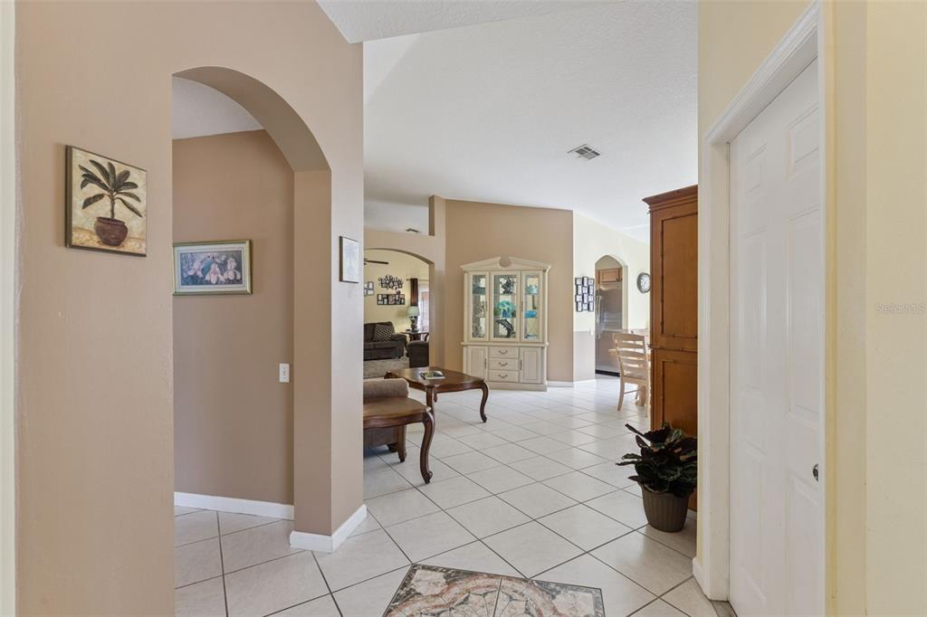 A view from a tiled entryway looking into a living room and dining area — 3136 CRANES COVE LOOP, KISSIMMEE, FL