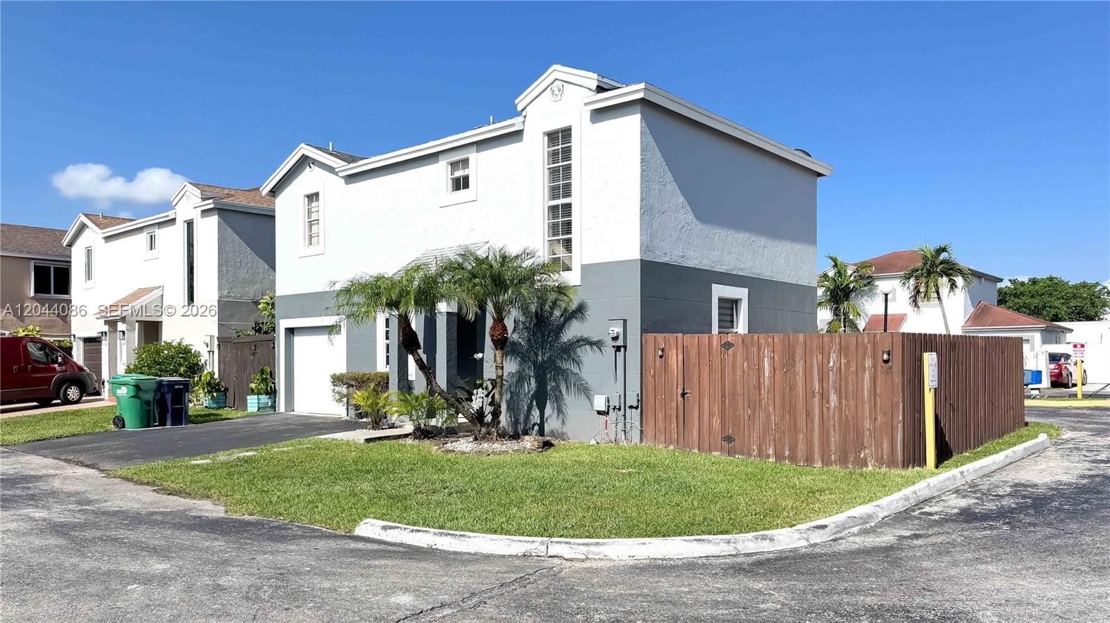 A two-story residential building with a gray exterior and a wooden fence stands outdoors — 9044 SW 148 Ct # 0, Miami FL 33196, MIAMI, FL