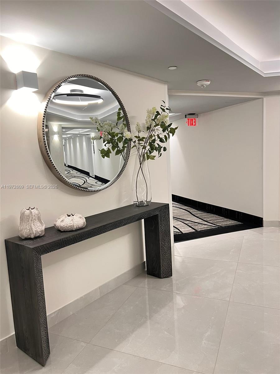 A hallway features a dark console table, a round mirror, and decorative vases — 3180 S Ocean Dr # 1418, Hallandale Beach FL 33009, HALLANDALE BEACH, FL