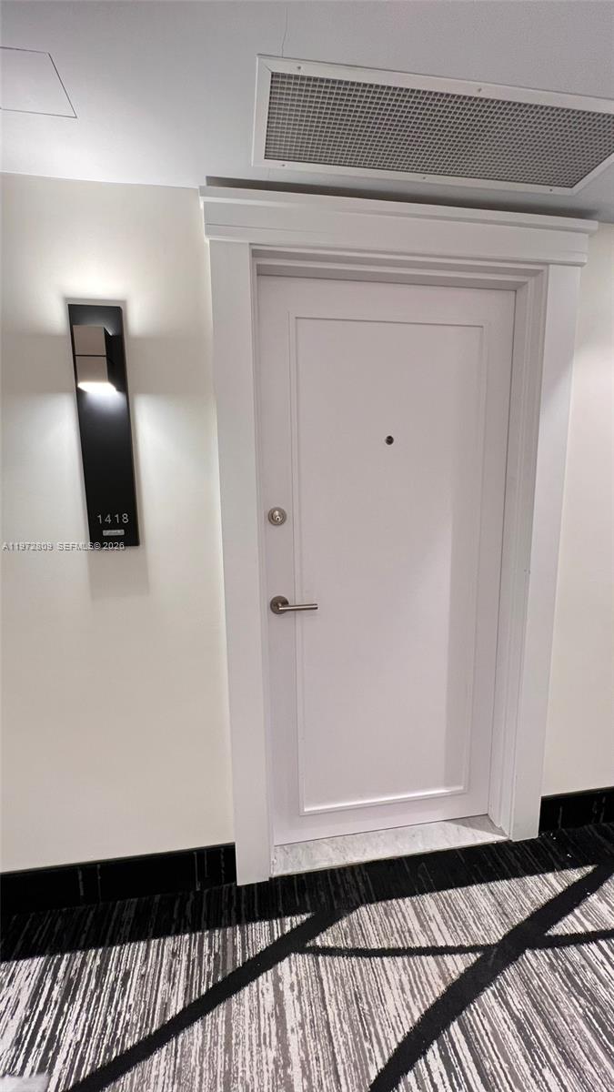 A white door with a silver handle and a room number sign on the wall — 3180 S Ocean Dr # 1418, Hallandale Beach FL 33009, HALLANDALE BEACH, FL