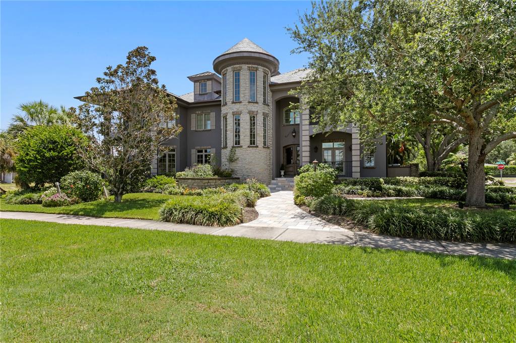 A two-story house with a stone turret, dark gray siding, and a paved walkway — 401 SNELL ISLE BOULEVARD NE, ST PETERSBURG, FL
