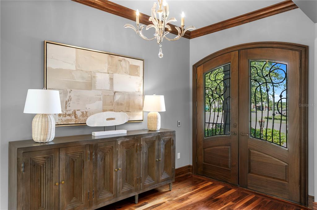 An entryway features a wooden console table, a chandelier, and double doors with glass inserts — 401 SNELL ISLE BOULEVARD NE, ST PETERSBURG, FL