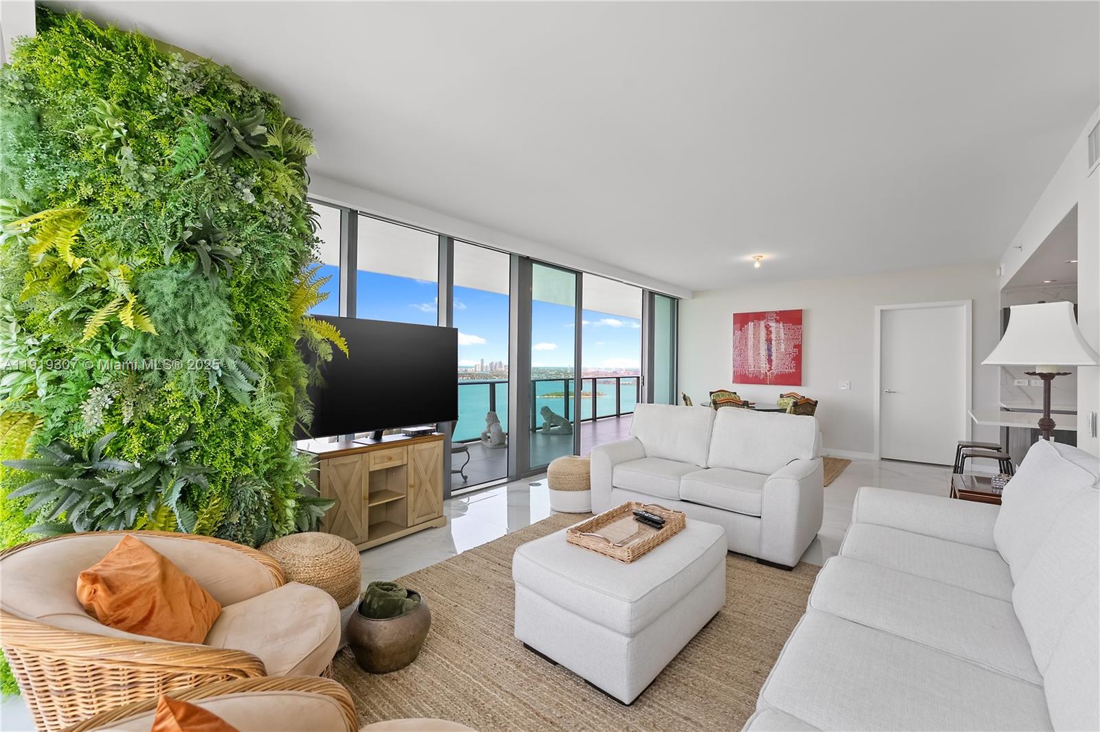 A living room features a large vertical garden wall, white furniture, and floor-to-ceiling windows — 3131 NE 7th Ave # 3106, Miami FL 33137, MIAMI, FL
