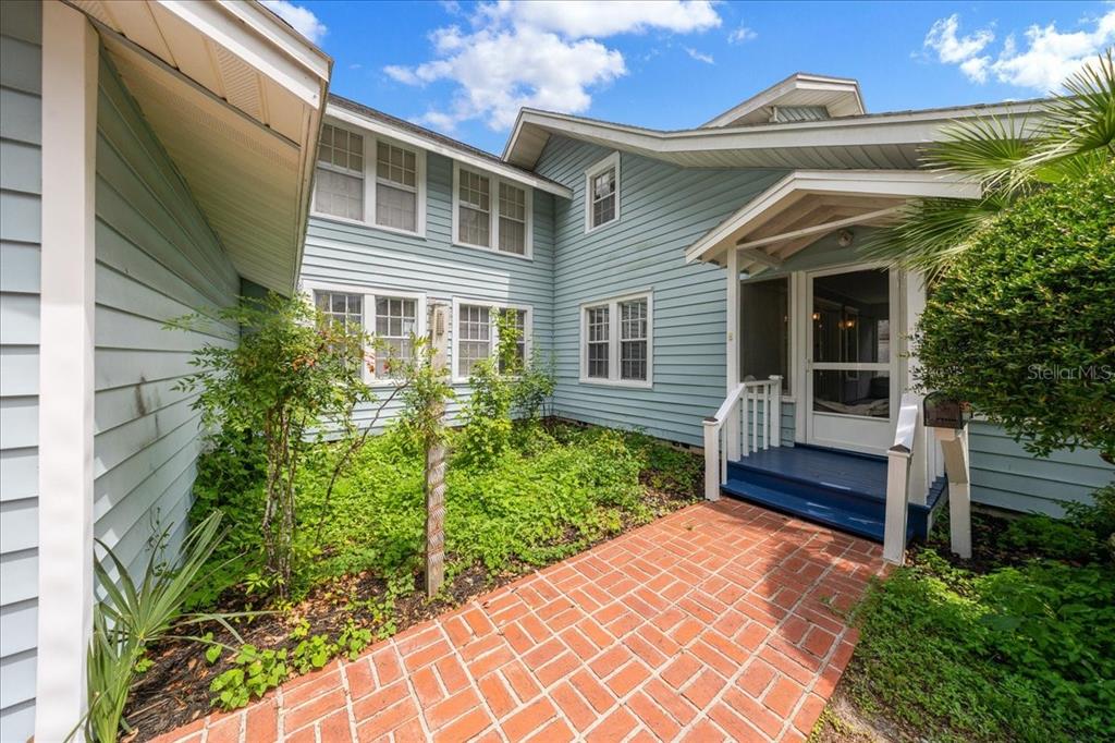A light blue house with a brick walkway leading to a covered front entrance — 319 CARNATION COURT, APOPKA, FL