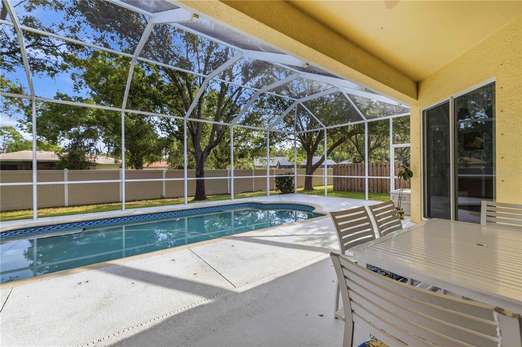 A screened-in patio features a swimming pool, concrete decking, and outdoor dining furniture — 8268 47TH STREET CIRCLE E, PALMETTO, FL