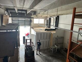 An interior view of a warehouse space featuring a mezzanine level, forklift, and concrete floors — 1750 W 39th Place # 1005, Hialeah FL 33012, HIALEAH, FL