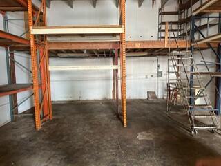 An industrial warehouse space features orange metal shelving units and a rolling metal staircase — 1750 W 39th Place # 1005, Hialeah FL 33012, HIALEAH, FL