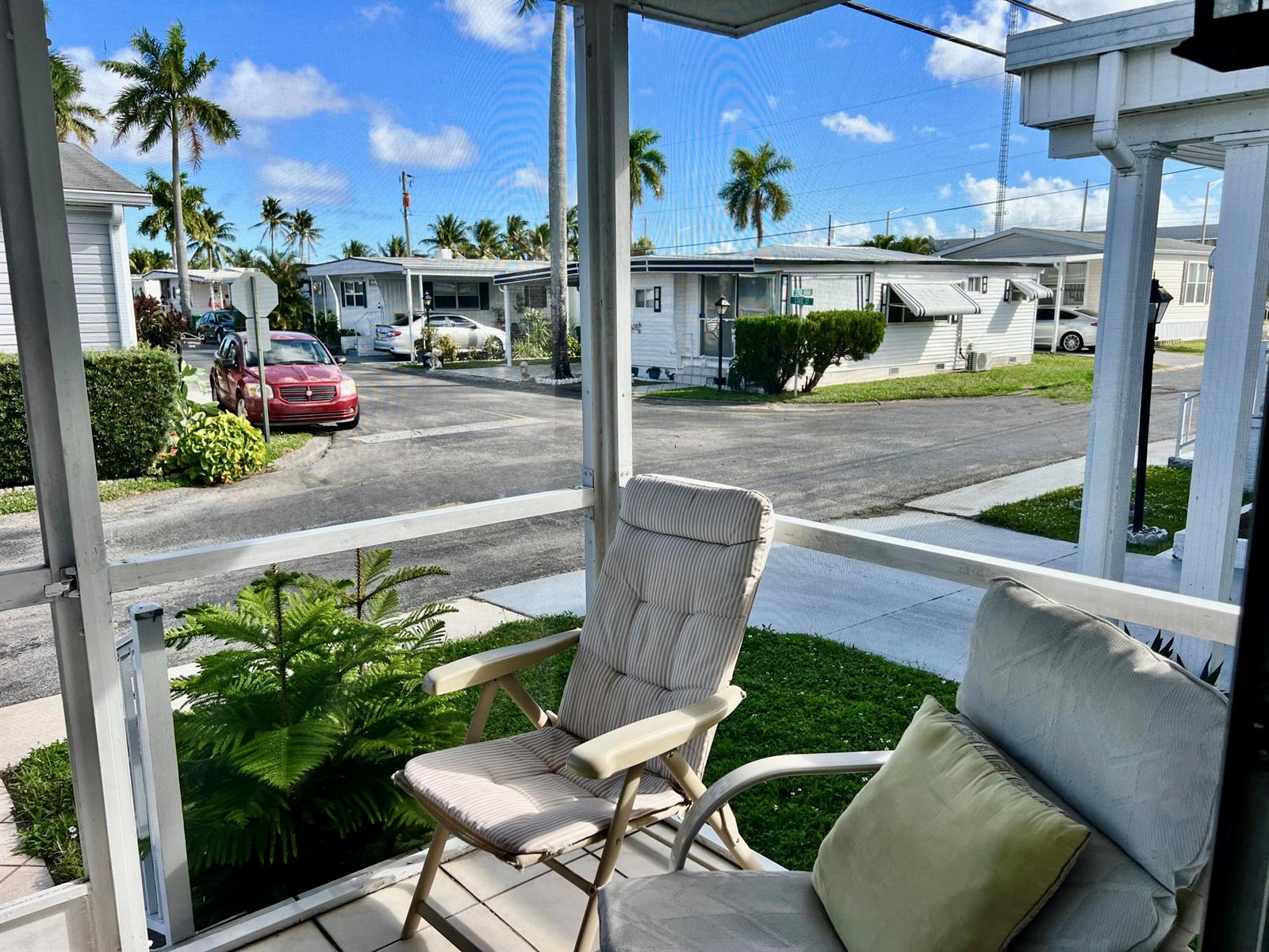 A view from a screened-in porch looking out at a residential street with mobile homes — 1552 S 33rd Road, Hollywood FL 33021, HOLLYWOOD, FL
