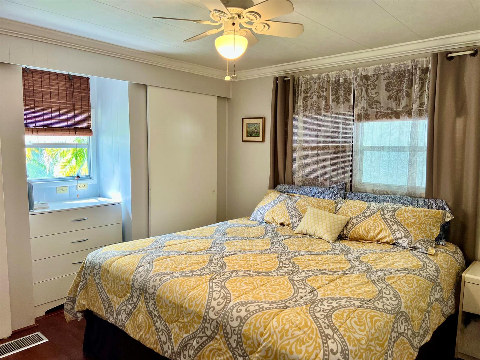 A bedroom features a bed with a yellow patterned comforter, a dresser, and window treatments — 1552 S 33rd Road, Hollywood FL 33021, HOLLYWOOD, FL