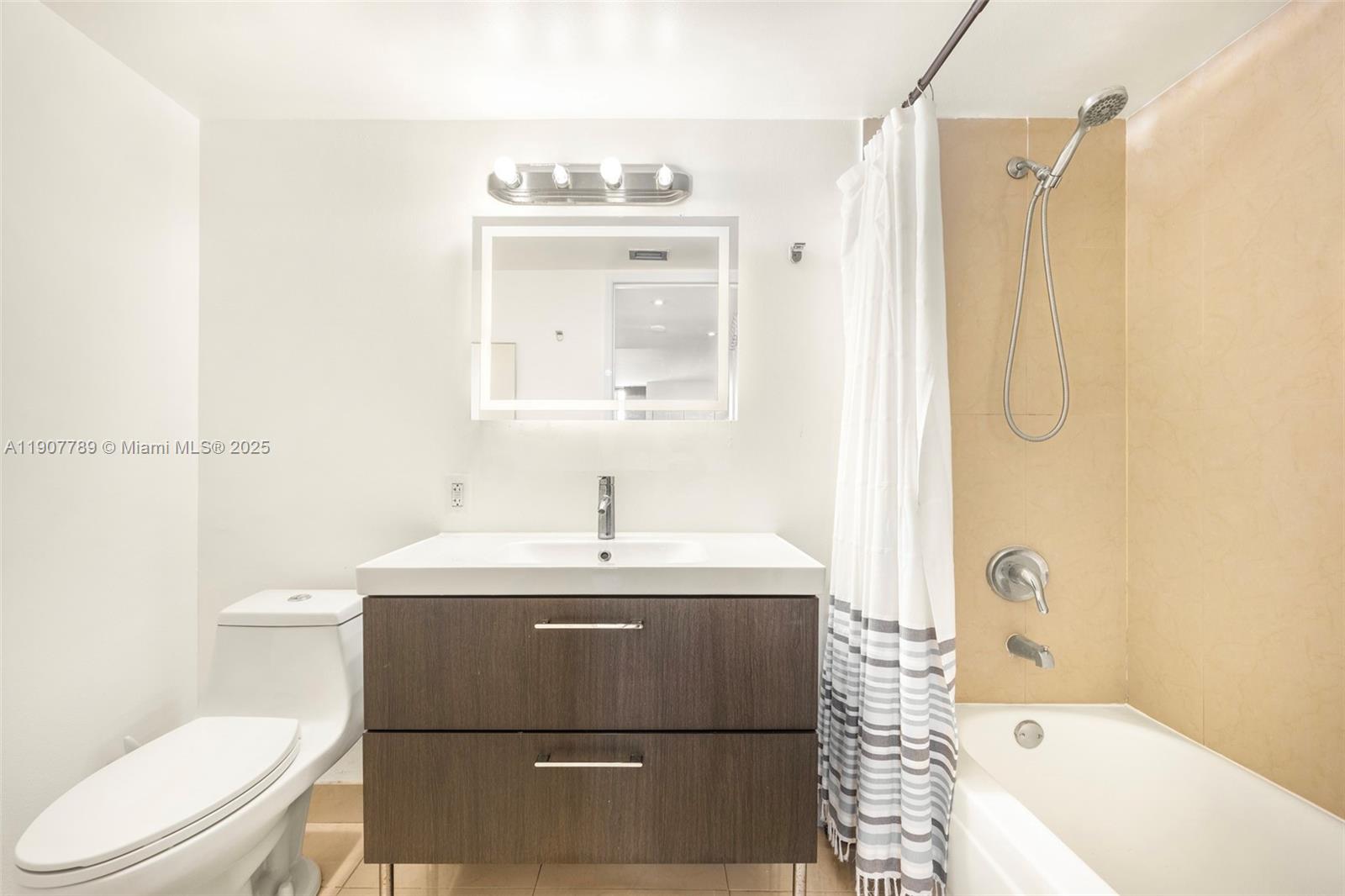 A bathroom features a dark wood vanity, a white toilet, and a shower-tub combination — 850 N Miami Ave # 906, Miami FL 33136, MIAMI, FL