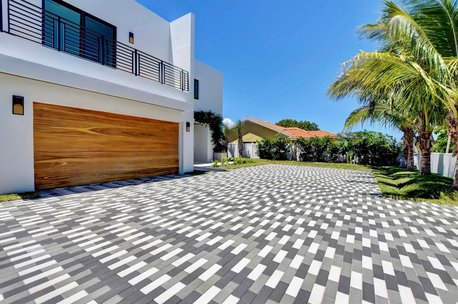 A modern white house with a wood garage door and a patterned paver driveway — 855 NW 4th Avenue, Boca Raton FL 33432, BOCA RATON, FL