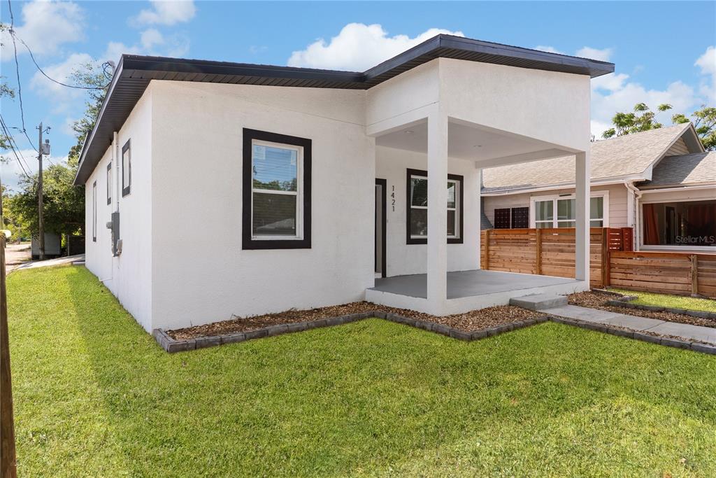 A white, single-story house with a covered front porch and dark window trim — 1421 35TH STREET S, ST PETERSBURG, FL