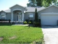 A single-story gray house with a front porch, a two-car garage, and a green lawn — OTHER CITY - IN THE STATE OF FLORIDA, FL