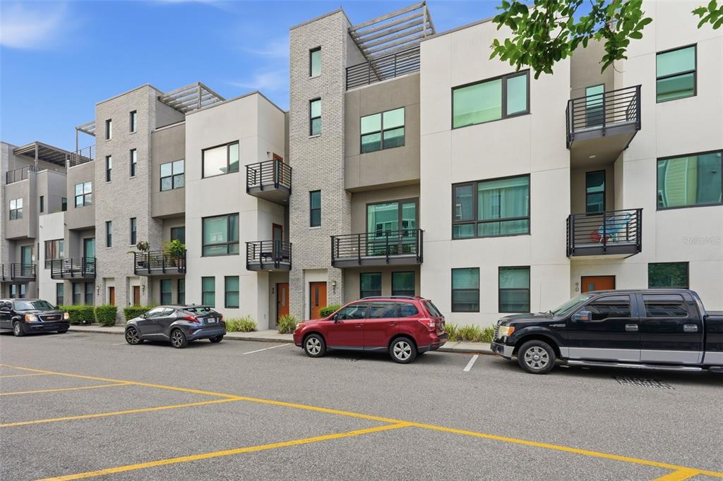 A row of modern multi-story townhomes with balconies and a parking lot in front — 2511 N GRADY AVENUE UNIT 89, TAMPA, FL