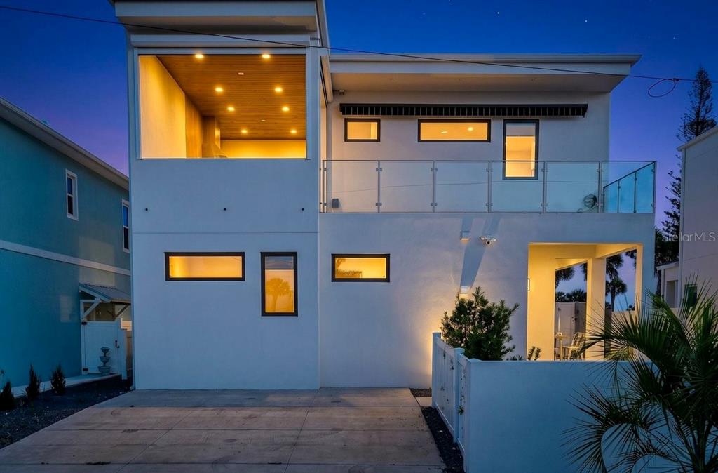 A modern two-story white house features a balcony, recessed lighting, and a concrete driveway — 1309 S ATLANTIC AVENUE, NEW SMYRNA BEACH, FL