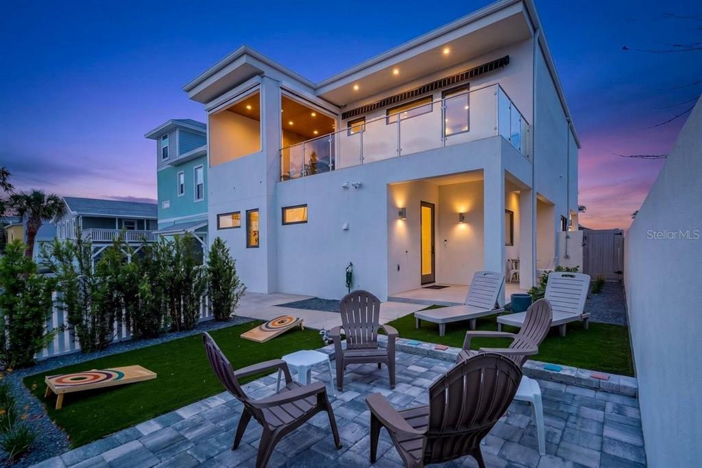 A modern two-story house with a patio, outdoor furniture, and a cornhole game set — 1309 S ATLANTIC AVENUE, NEW SMYRNA BEACH, FL