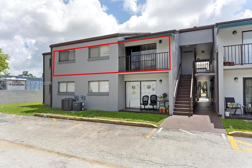 The exterior of a two-story apartment building features a second-floor balcony outlined in red — 7403 SW 152nd Ave # 2, Miami FL 33193, MIAMI, FL