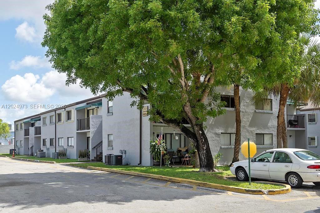 A multi-story apartment building exterior features a large tree and a parked white car — 7403 SW 152nd Ave # 2, Miami FL 33193, MIAMI, FL
