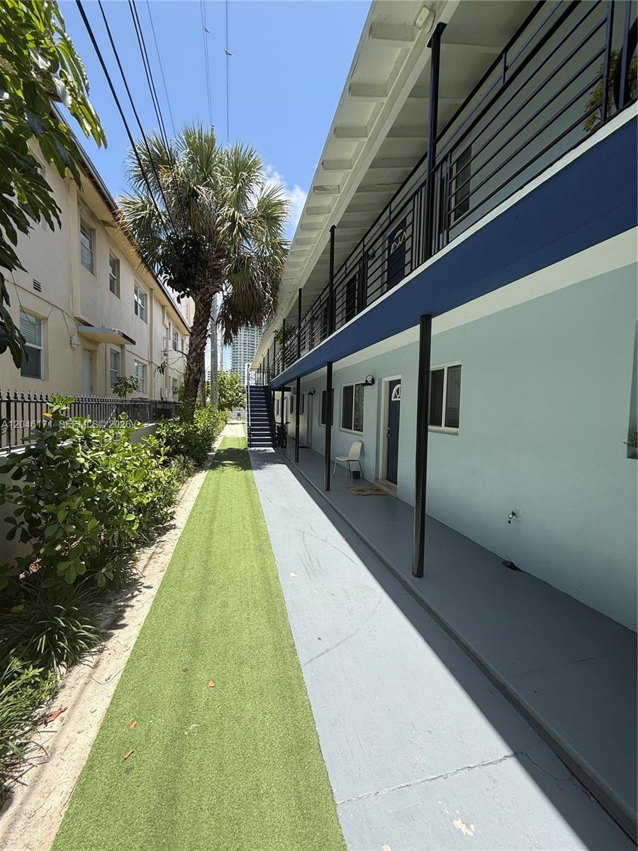 A view of an outdoor walkway between two apartment buildings with artificial turf — 1450 Lenox Ave # 5, Miami Beach FL 33139, MIAMI BEACH, FL