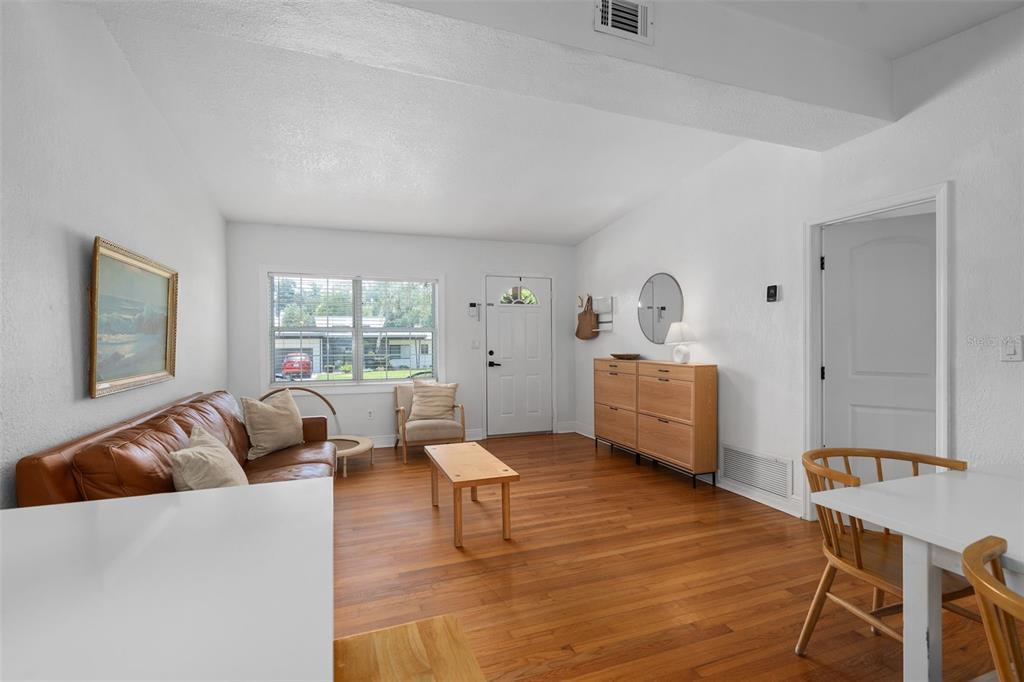 A living room with hardwood floors, a brown leather sofa, and a light wood cabinet — 1055 DRUID DRIVE, MAITLAND, FL