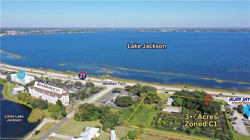 An aerial view shows a vacant lot near Lake Jackson, a highway, and nearby hotels — 1993 US HIGHWAY 27 S, SEBRING, FL