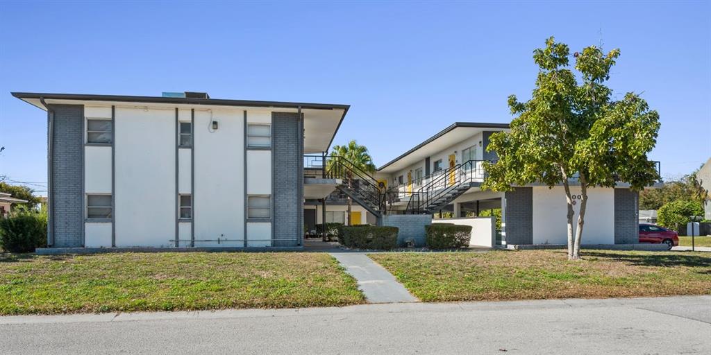 A two-story apartment building with a central staircase and a large tree in front — 300 S NIMBUS AVENUE, CLEARWATER, FL