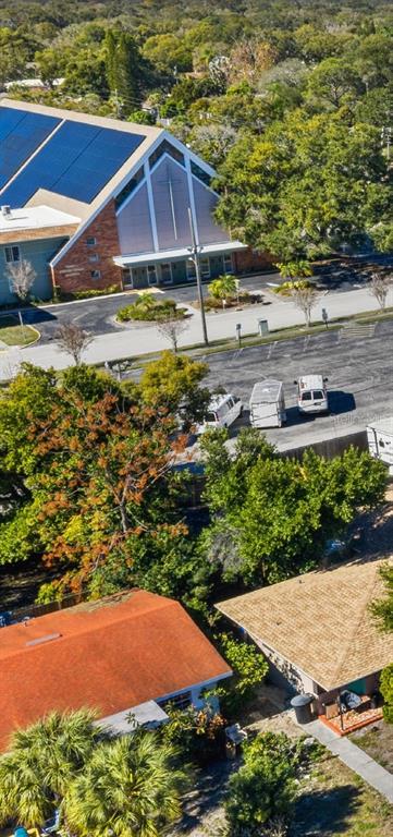 An aerial view shows a church with solar panels and nearby residential houses — 300 S NIMBUS AVENUE, CLEARWATER, FL