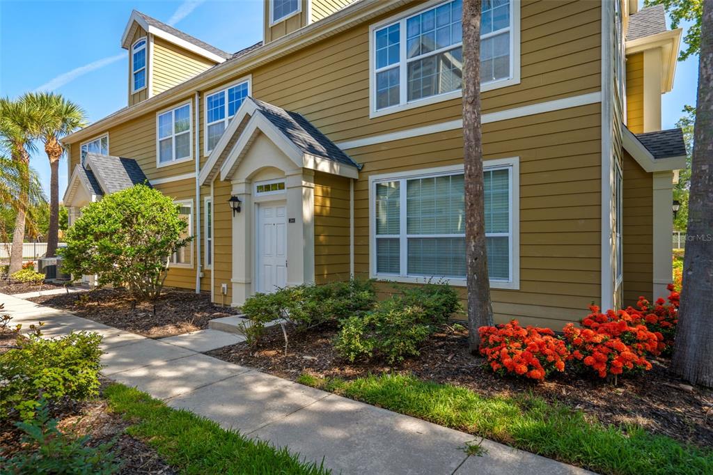 A two-story yellow house with white trim, a front entrance, and a concrete walkway — 5611 BIDWELL PARKWAY UNIT 204, SARASOTA, FL