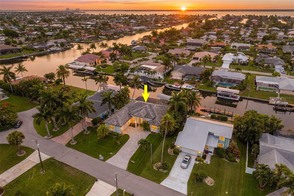 An aerial view of a waterfront house with a pool cage and a paved driveway — 3619 SE 16TH PLACE, CAPE CORAL, FL