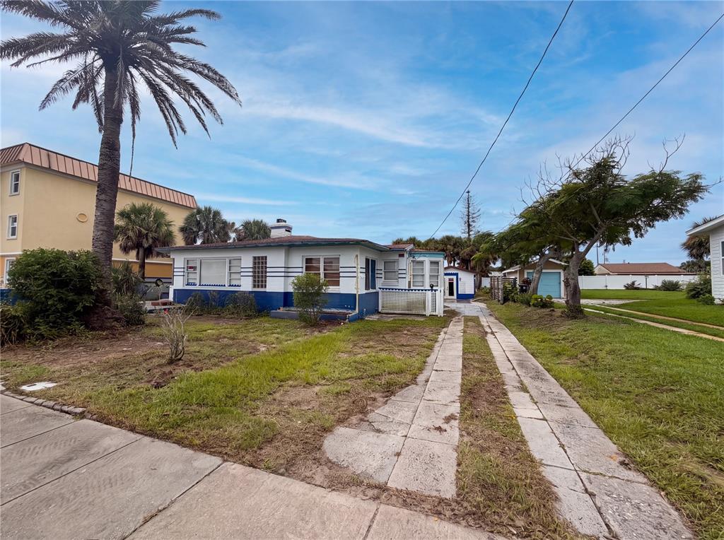 A single-story house with a blue and white exterior features a concrete driveway and palm tree — 370 HARTFORD AVENUE, DAYTONA BEACH, FL