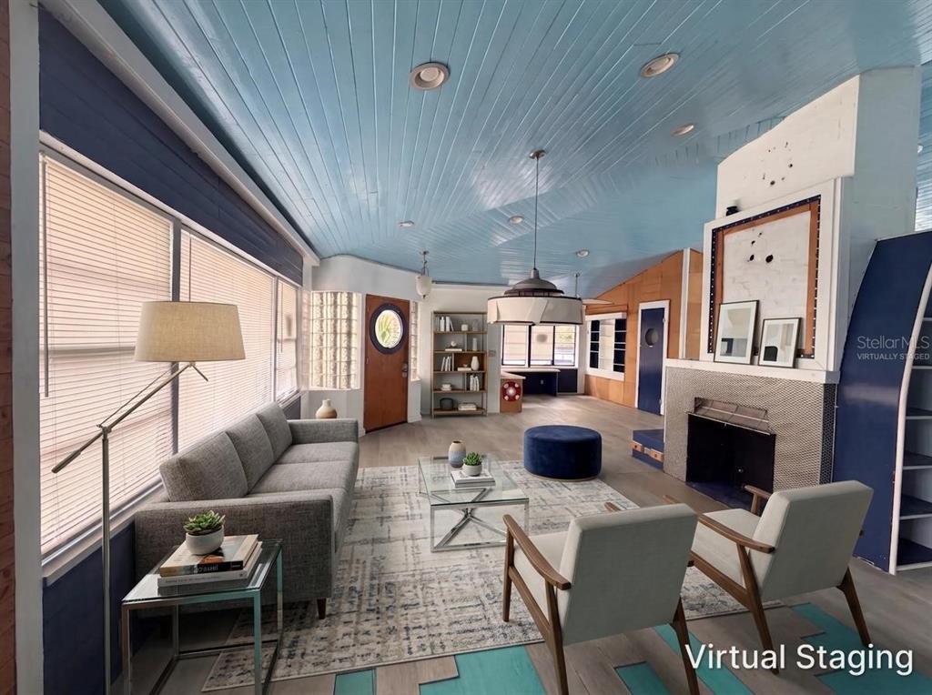 A living room with a blue wood-paneled ceiling, fireplace, and virtual staging furniture — 370 HARTFORD AVENUE, DAYTONA BEACH, FL