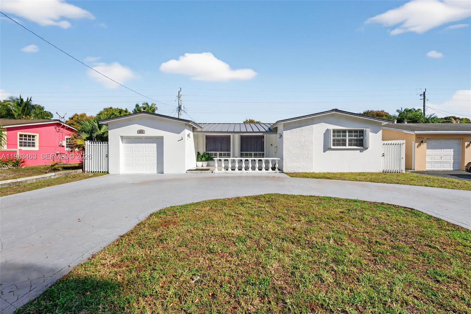 A white single-story house with a garage and a circular driveway under a blue sky — 7777 Fairway Blvd, Miramar FL 33023, MIRAMAR, FL