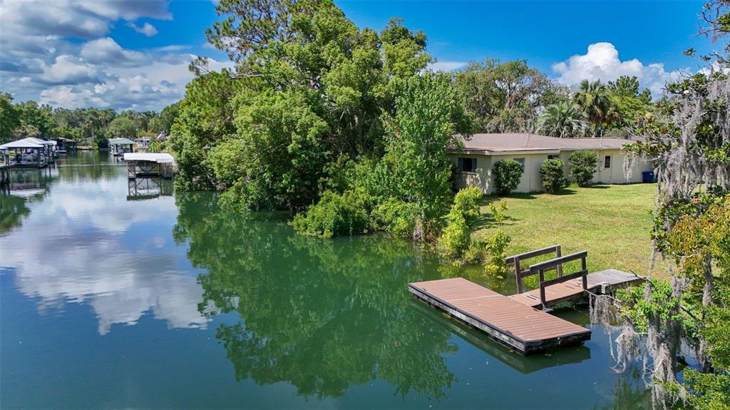 A waterfront house with a private dock sits along a canal surrounded by lush trees — 1209 SE PARADISE AVENUE, CRYSTAL RIVER, FL
