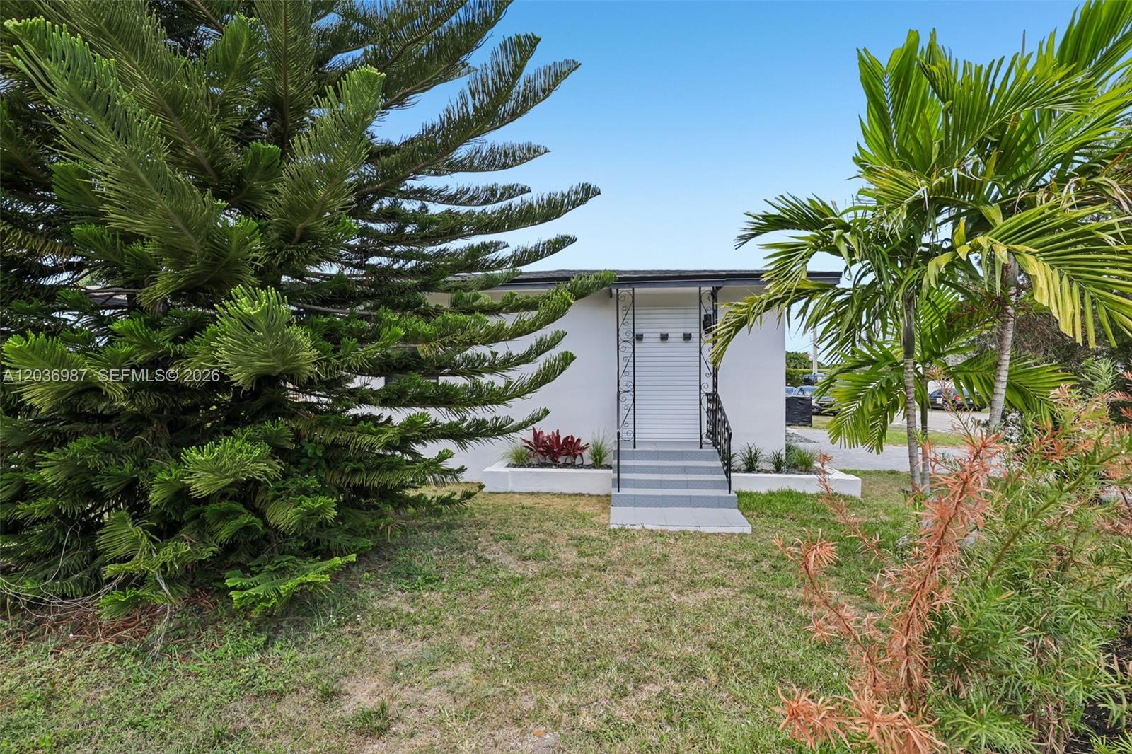 A white house exterior features a front entrance with steps, a railing, and landscaping — 6595 SW 31st St # 0, Miami FL 33155, MIAMI, FL