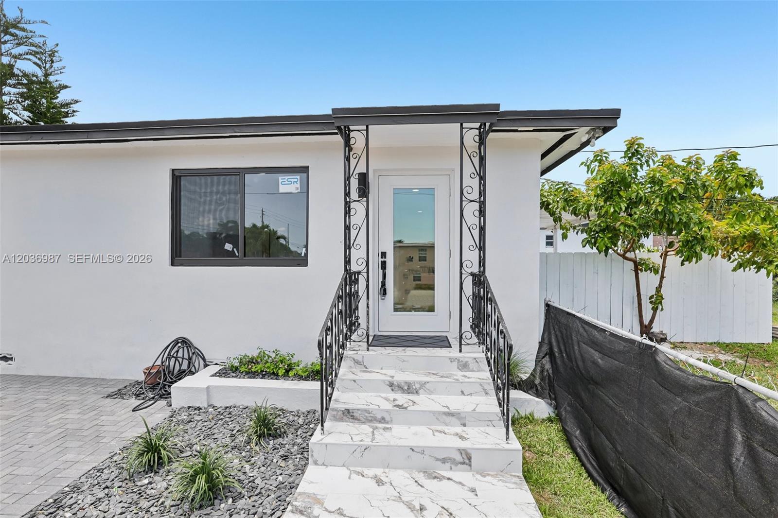 The exterior of a white house features a marble-tiled staircase and a glass front door — 6595 SW 31st St # 0, Miami FL 33155, MIAMI, FL