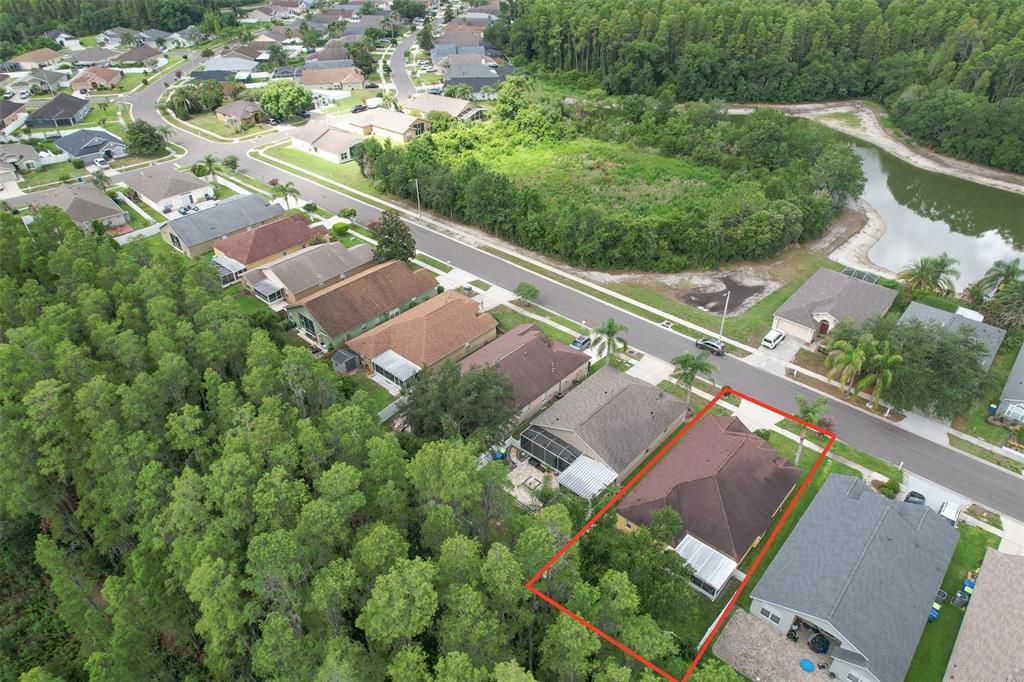 An aerial view shows a residential house with a red roof outlined in red — 30914 BURLEIGH DRIVE, WESLEY CHAPEL, FL
