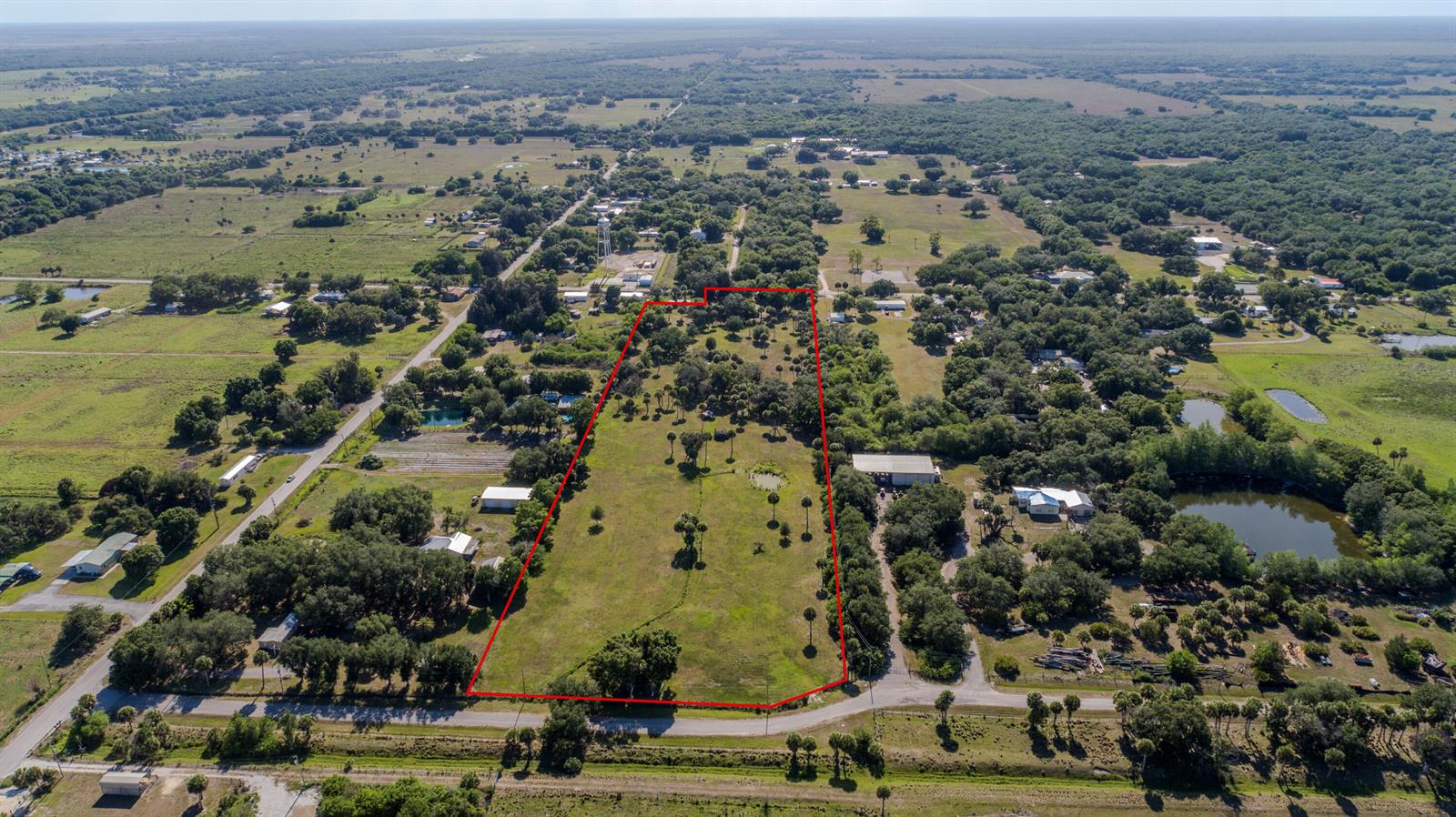 An aerial view shows a large, rectangular plot of land outlined in red with trees — 1100 Red Barn Rd N W, Moore Haven FL 33471, MOORE HAVEN, FL