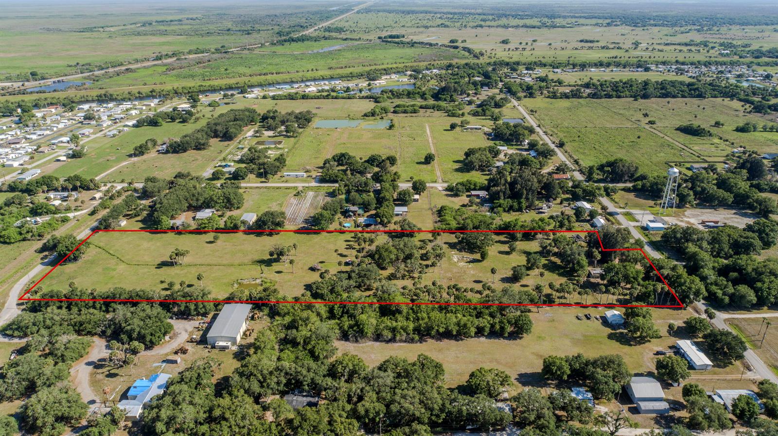 An aerial view shows a large, rectangular plot of land outlined in red — 1100 Red Barn Rd N W, Moore Haven FL 33471, MOORE HAVEN, FL