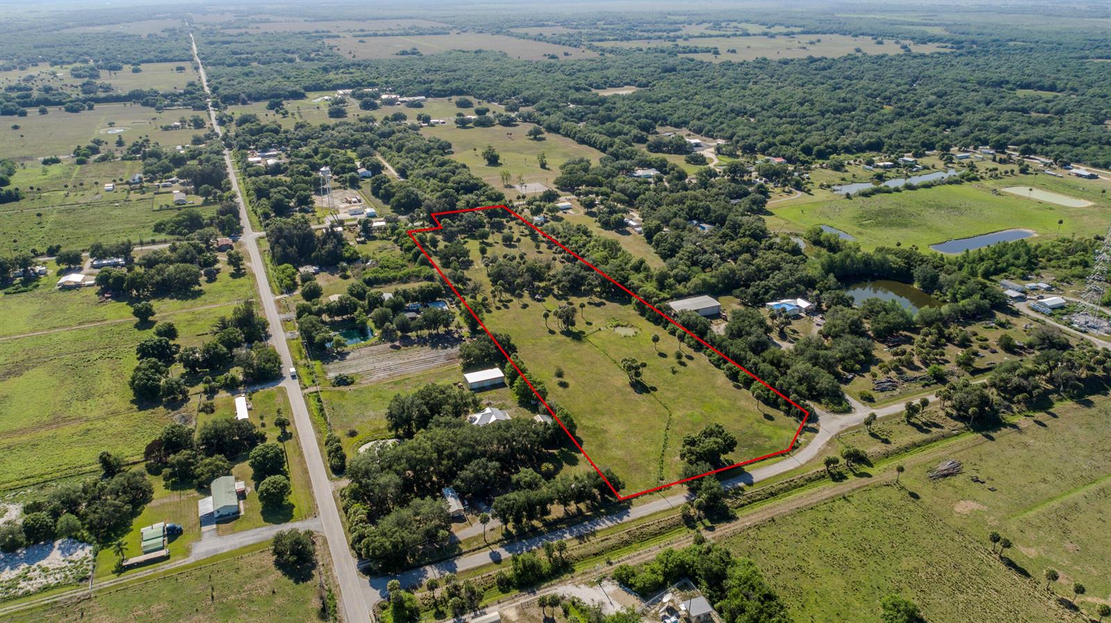 An aerial view shows a large, rectangular plot of land outlined in red — 1100 Red Barn Rd N W, Moore Haven FL 33471, MOORE HAVEN, FL