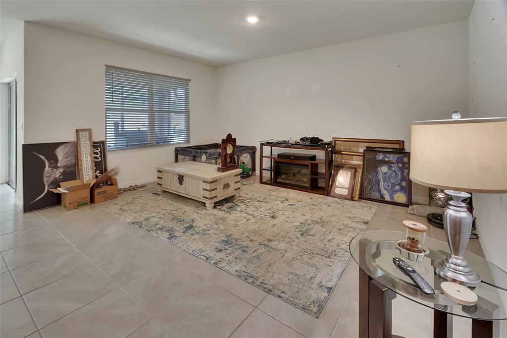 A living room with tile flooring, a large area rug, and various furniture and decor — 1235 WINTER GRAY CIRCLE, DELTONA, FL