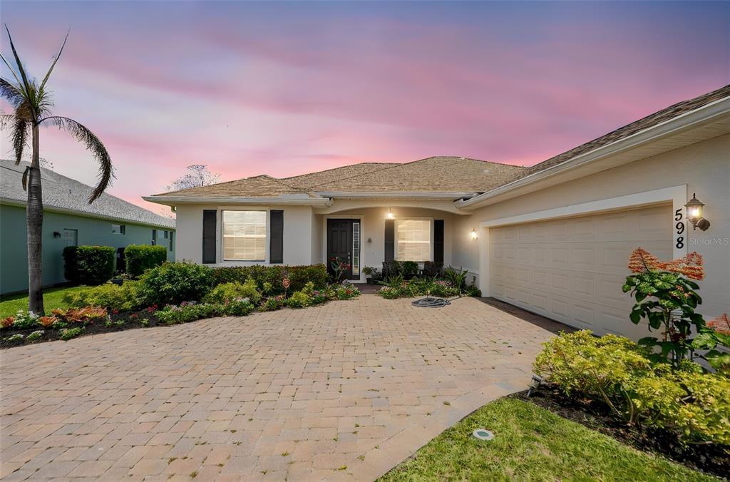A single-story house with a paved driveway, a two-car garage, and a landscaped front yard — 598 GOSSAMER WING WAY, SEBASTIAN, FL