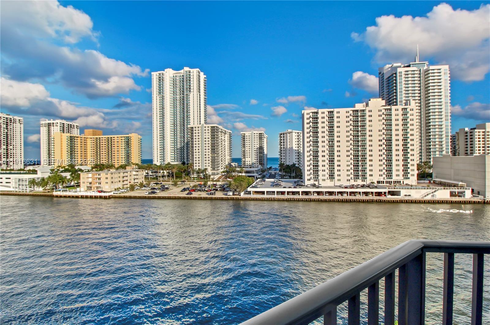 A view of a waterfront cityscape featuring several high-rise apartment buildings and a parking lot — 800 Parkview Dr # 821, Hallandale Beach FL 33009, HALLANDALE BEACH, FL