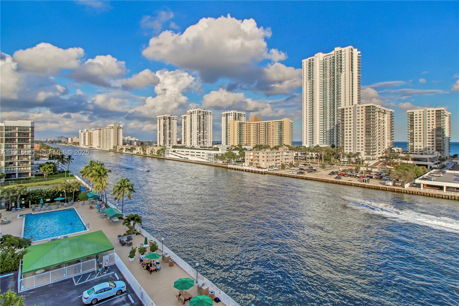 An elevated view shows a waterfront swimming pool, a parking lot, and high-rise buildings — 800 Parkview Dr # 821, Hallandale Beach FL 33009, HALLANDALE BEACH, FL