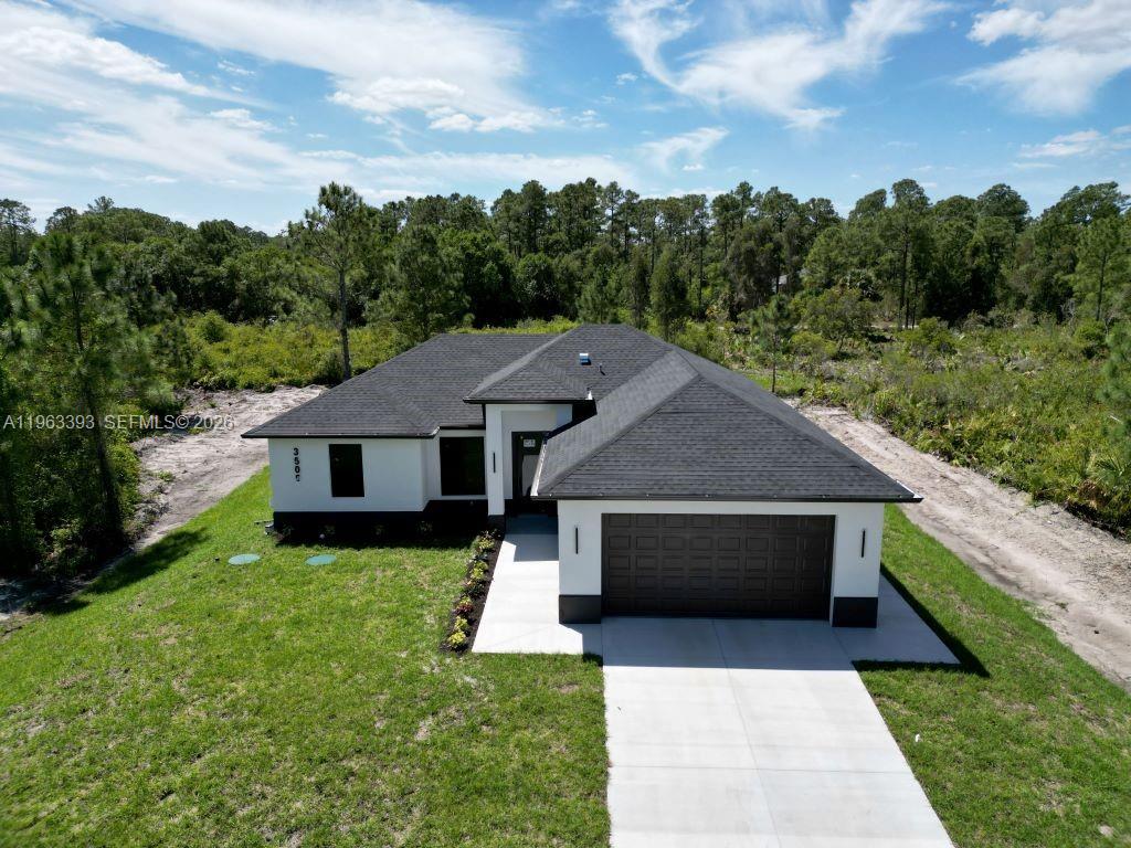 An aerial view shows a modern single-story house with a dark roof and white exterior — 3505 57TH ST, Lehigh Acres FL 33971, LEHIGH ACRES, FL