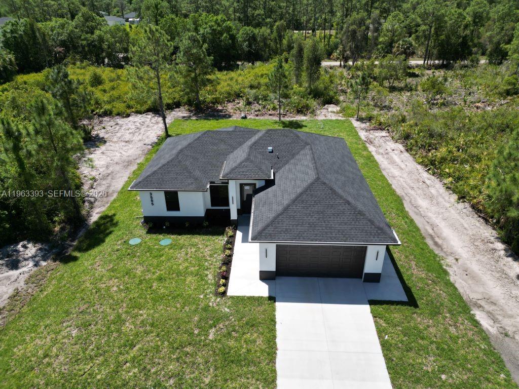 An aerial view shows a modern single-story house with a dark roof and white exterior — 3505 57TH ST, Lehigh Acres FL 33971, LEHIGH ACRES, FL