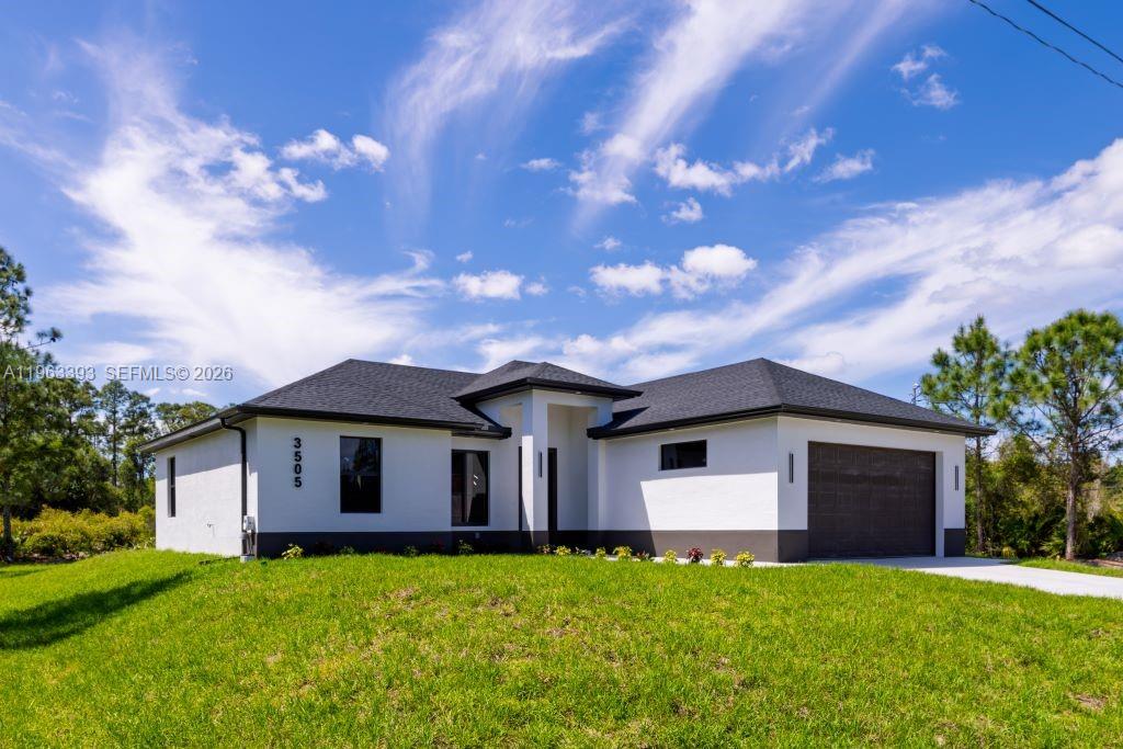 A single-story house with white stucco walls, a dark roof, and a two-car garage — 3505 57TH ST, Lehigh Acres FL 33971, LEHIGH ACRES, FL
